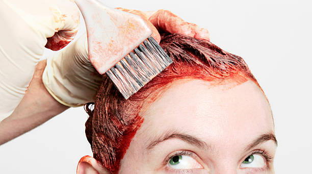 Seeing Red Permanent hair dye being applied with a watchful eye. haircolor stock pictures, royalty-free photos & images